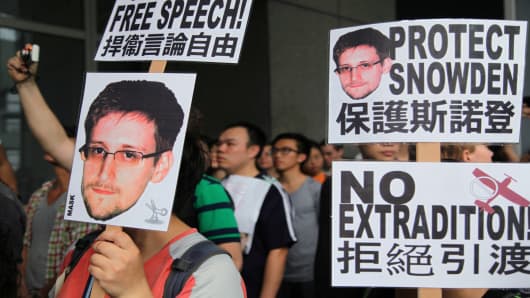Protesters in Hong Kong hold placards during a rally in support of Edward Snowden.